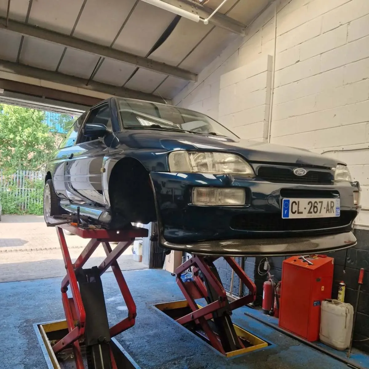 Ford Escort on a scissor lift in the Flowtech Exhausts workshop Dagenham